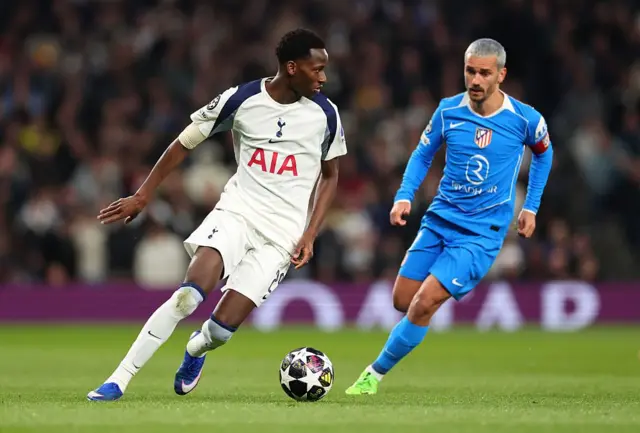 Pape Matar Sarr (Tottenham) court avec le ballon sous la pression d'Antoine Griezmann (Atlético de Madrid) lors du match retour des huitièmes de finale de l'UEFA Champions League 2025/26