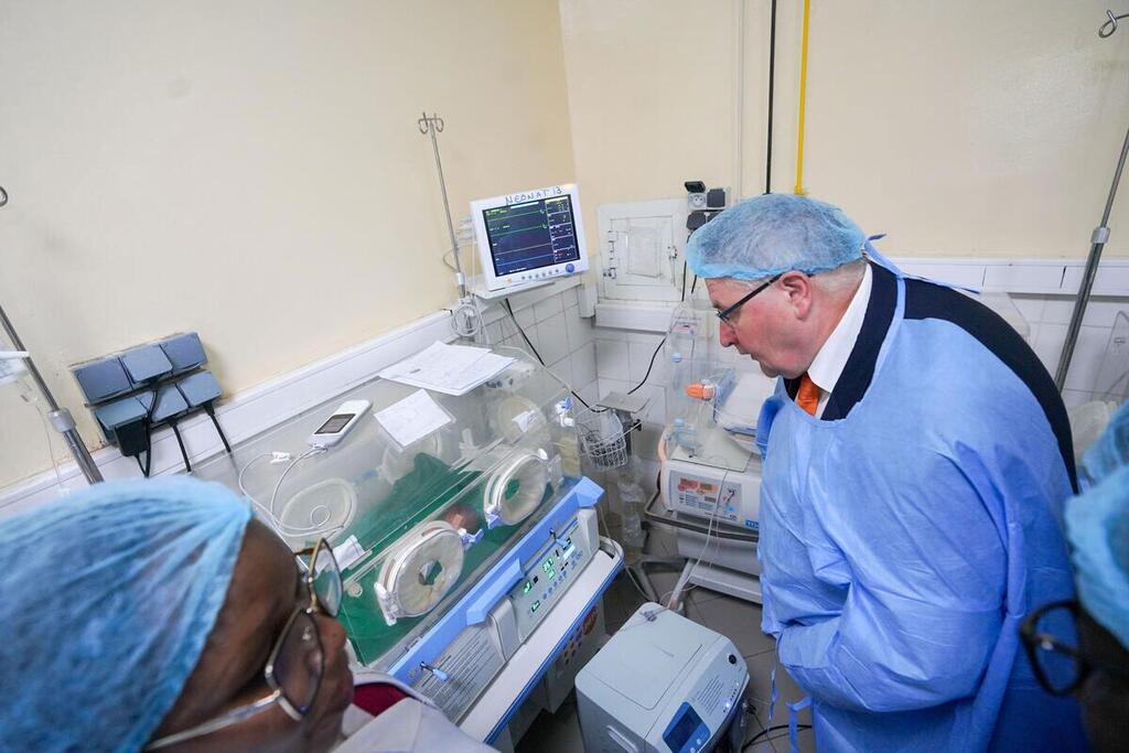Le directeur exécutif adjoint de l'UNFPA, Andrew Saberton, observe un incubateur dans une maternité d'un hôpital au Tchad, vêtu d'une tenue médicale.