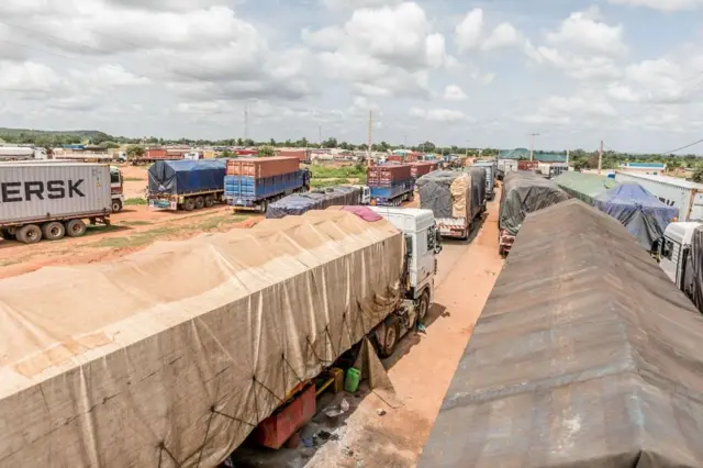 Files de camions immobilisés à la frontière bénino-nigérienne, symbole des conséquences économiques de la crise
